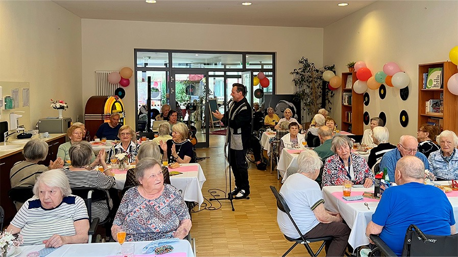 Senior*innen h&ouml;ren Live-Musik der 5oer und 60er Jahre bei der Sommer-Mottoparty in der Seniorenresidenz Park Sanssouci