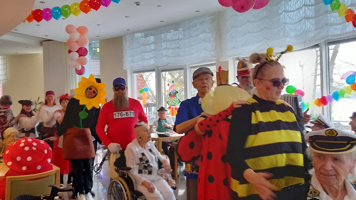 Bunte Faschingsfeier im ProCurand Seniorenresidenz Am Straussee: Bewohner*innen in fantasievollen Kost&uuml;men feiern ausgelassen zwischen Luftballons und Dekorationen. Die Stimmung wirkt fr&ouml;hlich, lebendig und gemeinschaftlich.