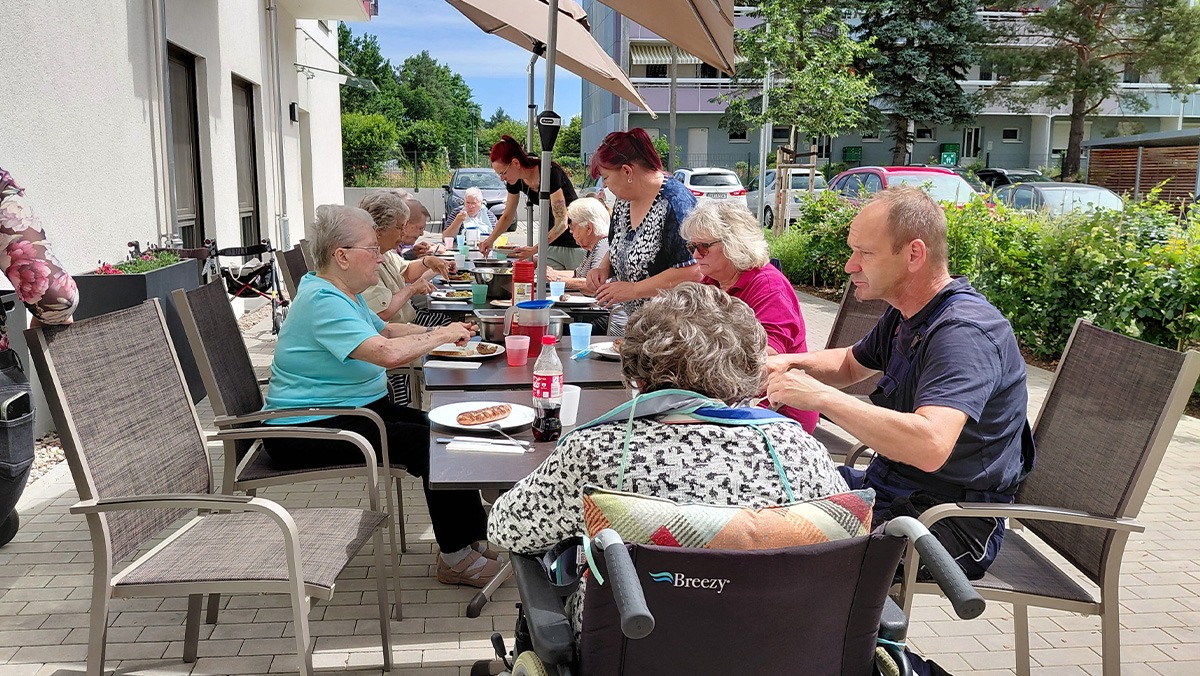 Senior*innen beim Grillfest auf der Terrasse der Tagespflege Eberswalde